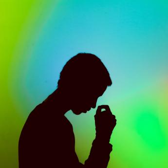 A figure appears sad against a colorful background